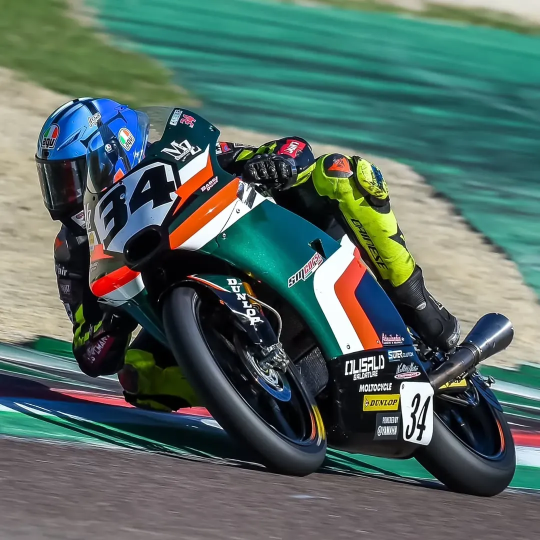Moto da corsa numero 34 con adesivo OLISALD Saldature in curva su pista
