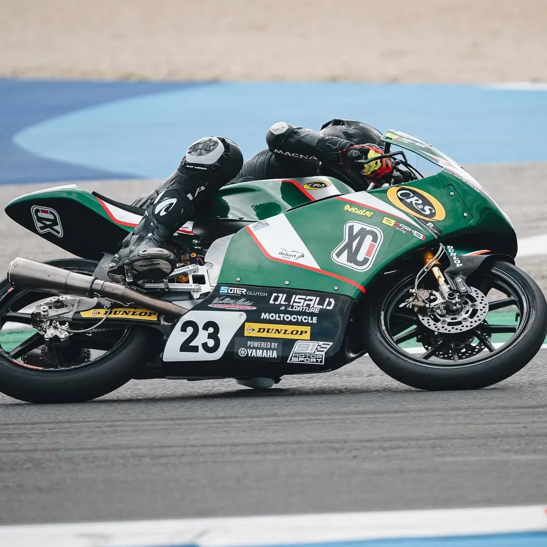 Moto da corsa numero 23 con adesivo OLISALD in curva su pista