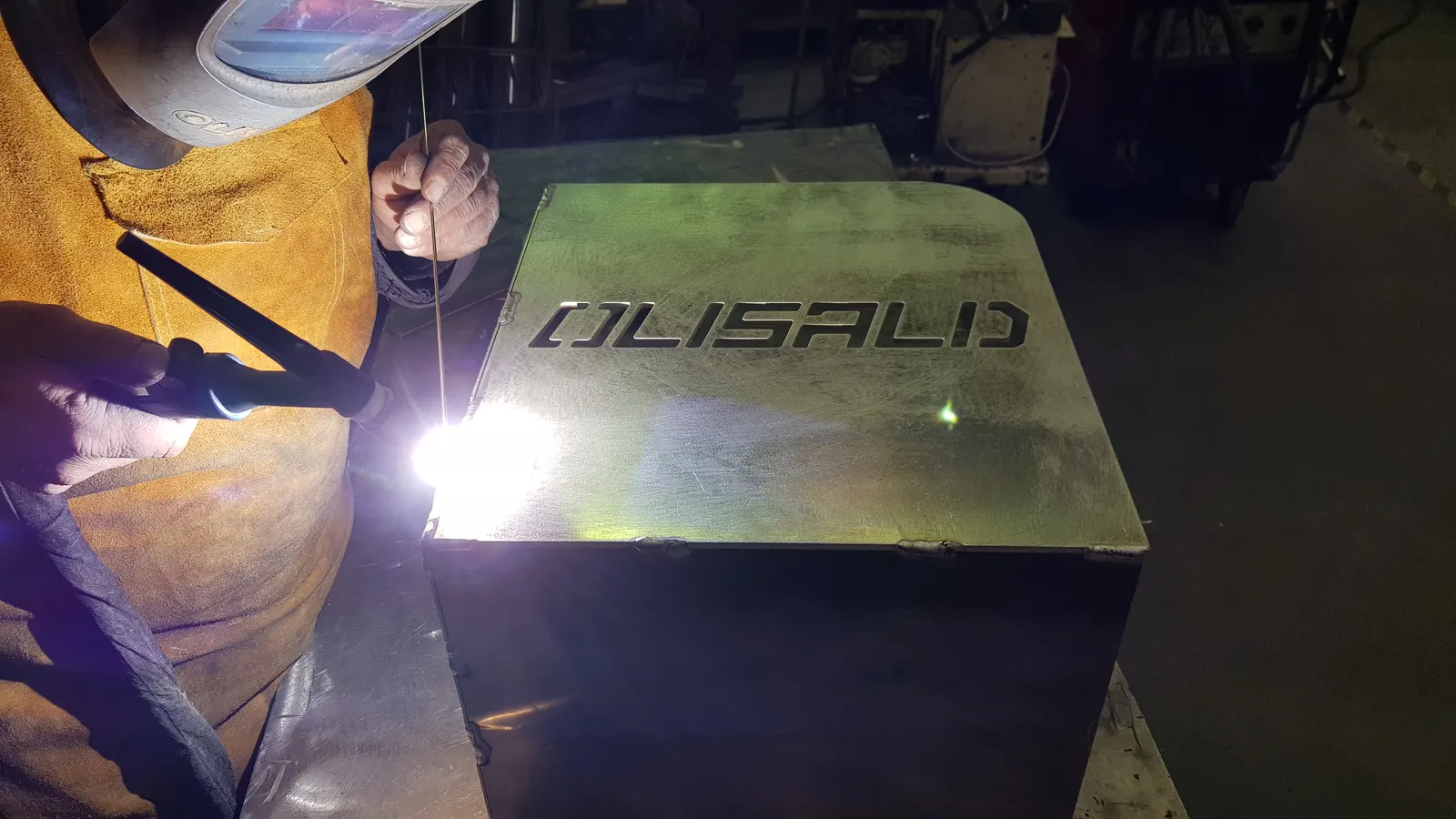 Saldatura TIG di una scatola metallica con il logo OLISALD inciso nel coperchio
